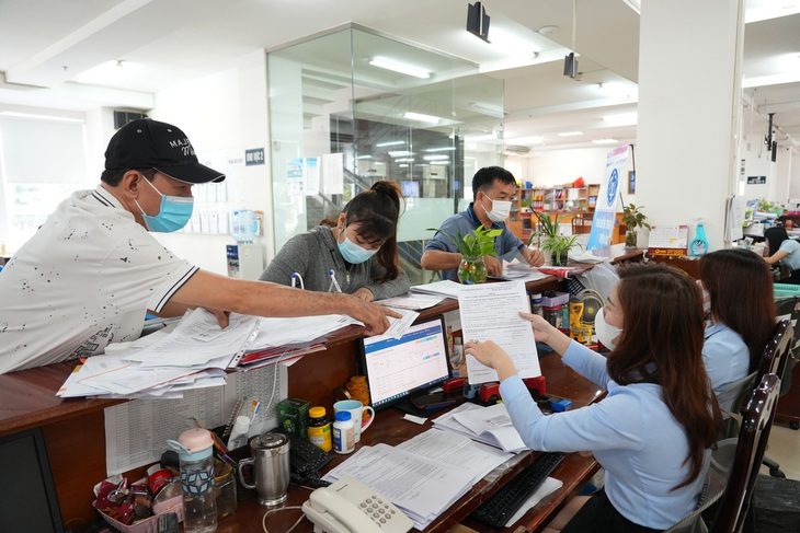 Phản hồi cuối tuần: Cách nào chấm dứt nợ đóng bảo hiểm xã hội? - Ảnh 1. Người lao động làm thủ tục tại Bảo hiểm xã hội TP.HCM, sáng 22-12 - Ảnh: HỮU HẠNH