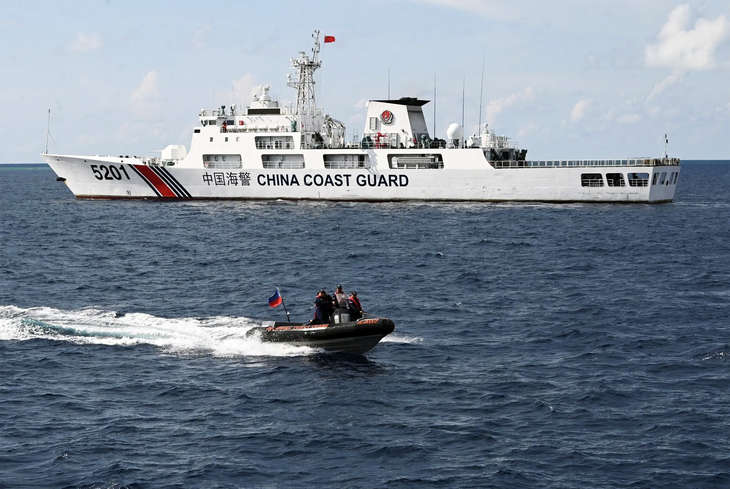Biển Đông cần một COC như thế nào? - Ảnh 1. Xuồng cao tốc của tuần duyên Philippines đi ngang qua tàu hải cảnh Trung Quốc ở bãi Cỏ Mây (thuộc quần đảo Trường Sa của Việt Nam) hồi tháng 4-2023 - Ảnh: AFP